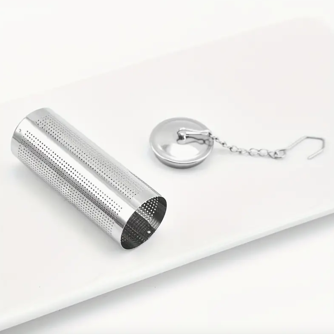 Metallic tea infuser with a keychain on a white background